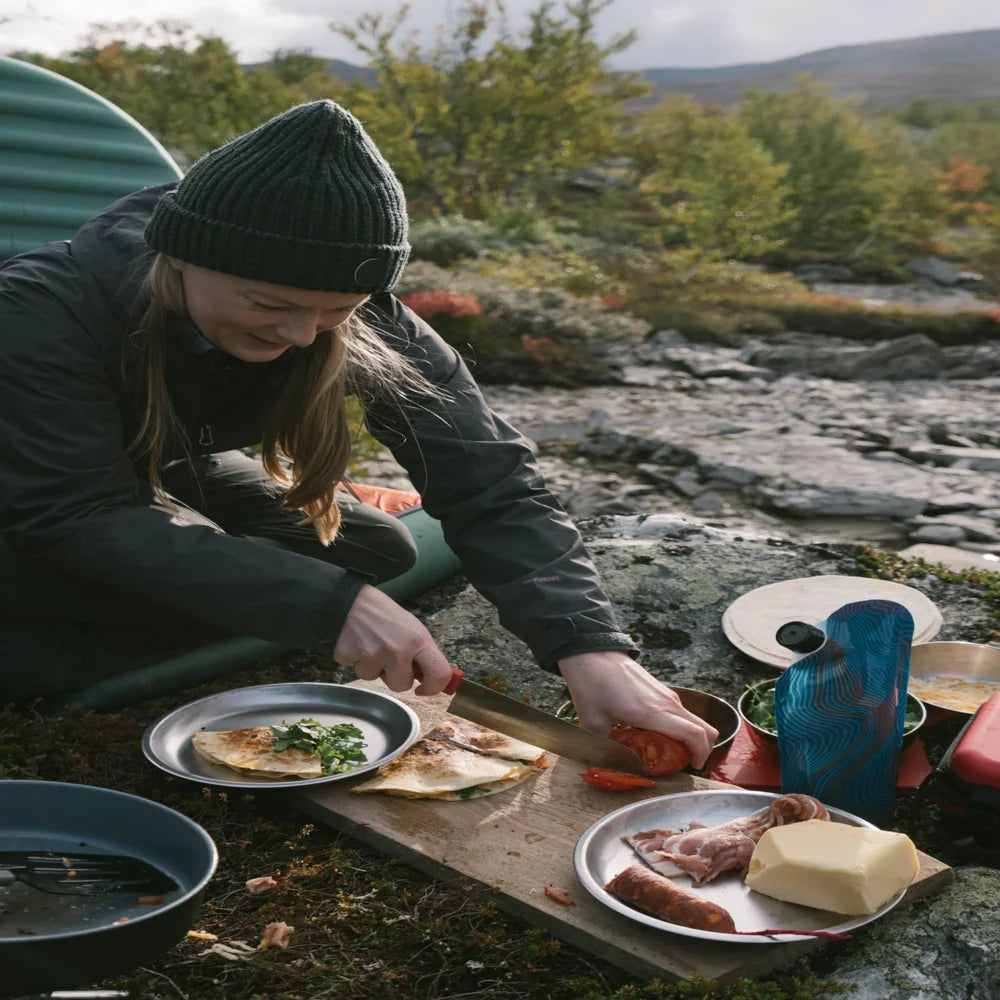 MSR Alpine Plate used for outdoor meal prep with food on cutting board at campsite