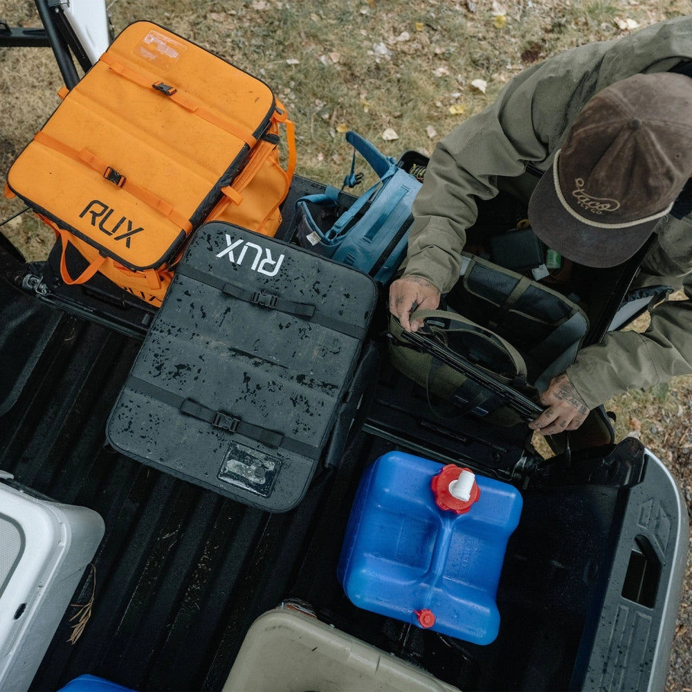 RUX 70L Pack durable waterproof gear storage system in truck bed with outdoor equipment for camping overlanding hunting and adventure travel