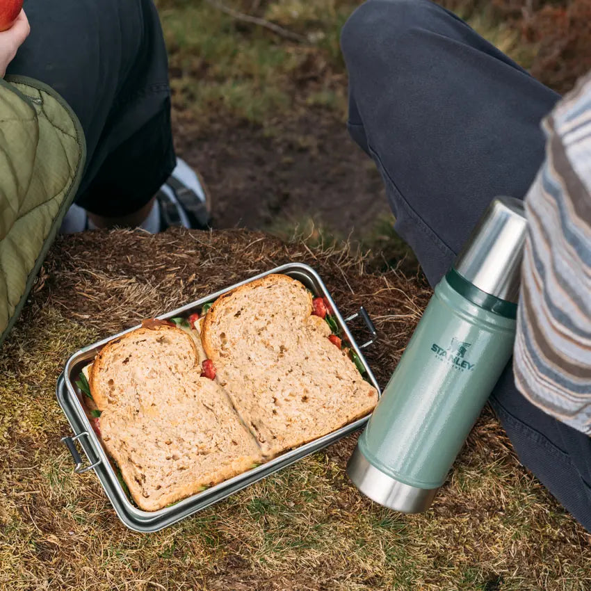 Stanley Legendary Useful Box 1.25 QT packed with a sandwich beside a Stanley bottle outdoors