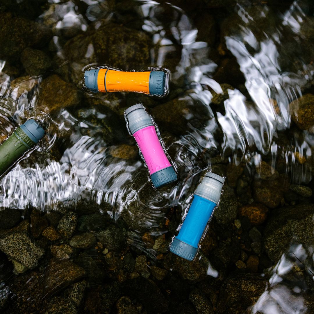 Platypus quickdraw filters floating in shallow stream water showing multiple colour options.