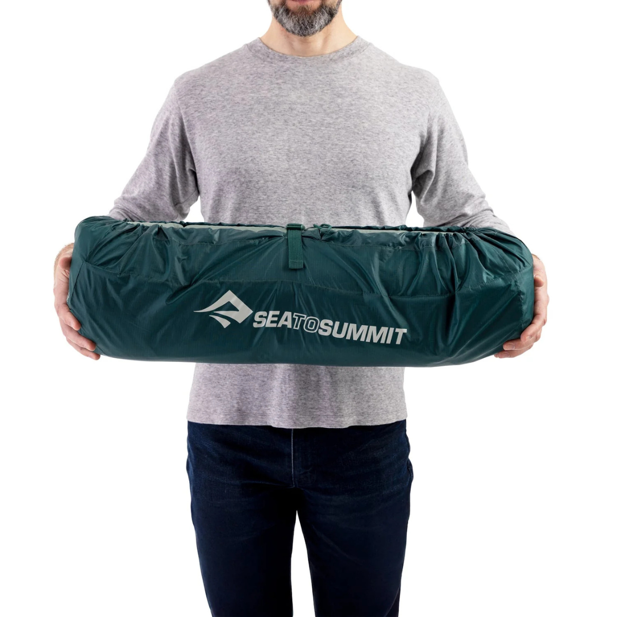 Sea to Summit Comfort Deluxe regular rectangular wide packed down and held by person 