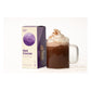 Alpine Start Hot Cocoa 5-packet box next to tall glass mug filled with rich hot cocoa topped with whipped cream and cocoa powder dusting on white background