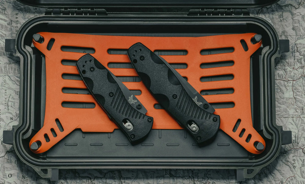 Benchmade Mini Barrage 585 folding knives displayed in protective case with organized storage layout