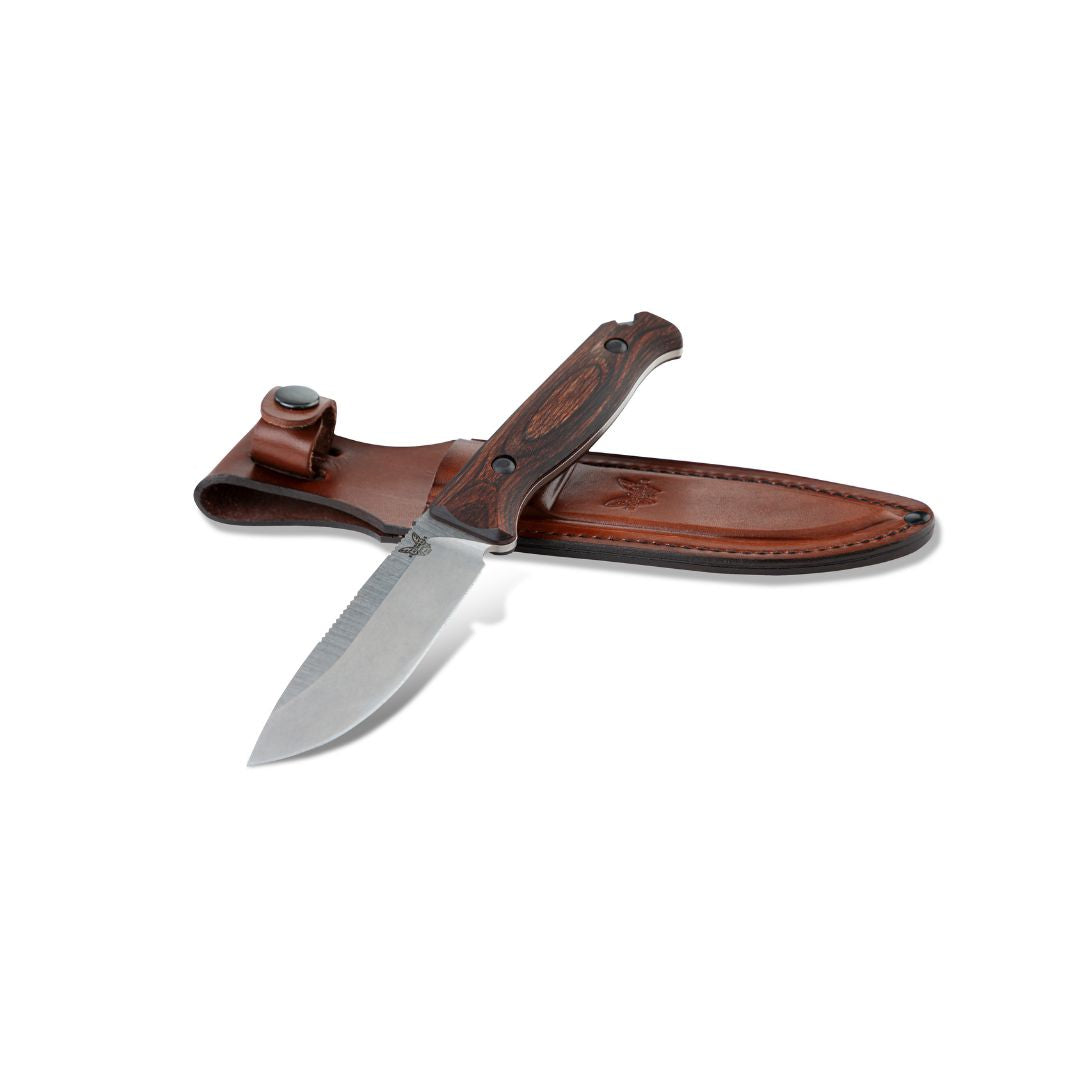 Benchmade Saddle Mountain Skinner knife positioned on leather sheath at an angle.
