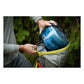 Hiker placing collapsed BVONE bear canister into a backpack in a forest setting, demonstrating compact packable size when collapsed for backpacking and wilderness camping