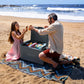Family using an EcoFlow Glacier Classic cooler on a sandy beach with the lid open and food inside