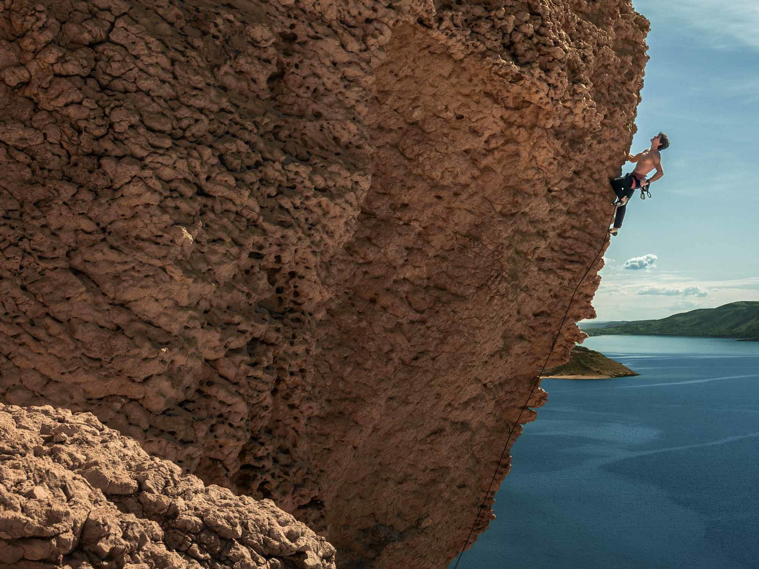 Garmin Fenix 8 smartwatch worn by climber scaling cliff above ocean
