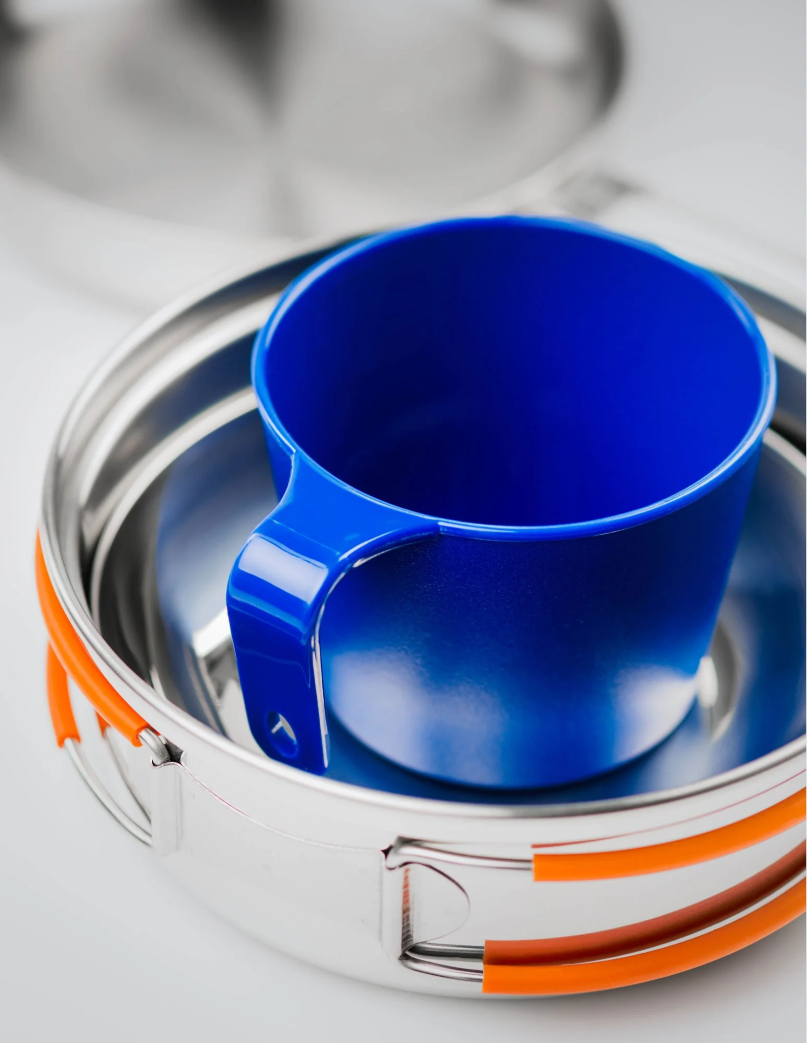 GSI Outdoors Glacier stainless mess kit with blue camping cup nested inside pot for compact storage