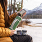 Pouring food from GSI Outdoors Glacier insulated travel stack in outdoor setting