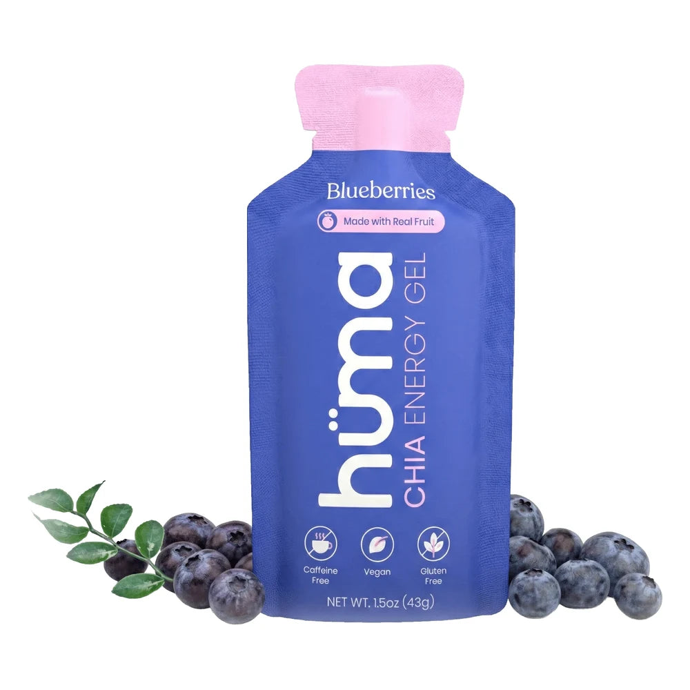 Huma Chia Energy Gel Blueberries flavor 1.5oz packet front hero on white background showing blue and purple packet with pink cap, Blueberries flavor name, Made with Real Fruit badge, h√ºma Chia Energy Gel branding, and Caffeine Free Vegan and Gluten Free icons, surrounded by fresh blueberries
