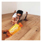 Humorous lifestyle photo of a man in a white t-shirt and glasses doing a low crawl on a hardwood floor reaching eagerly toward a yellow Huma Chia Energy Gel Mangoes packet being held out in the foreground