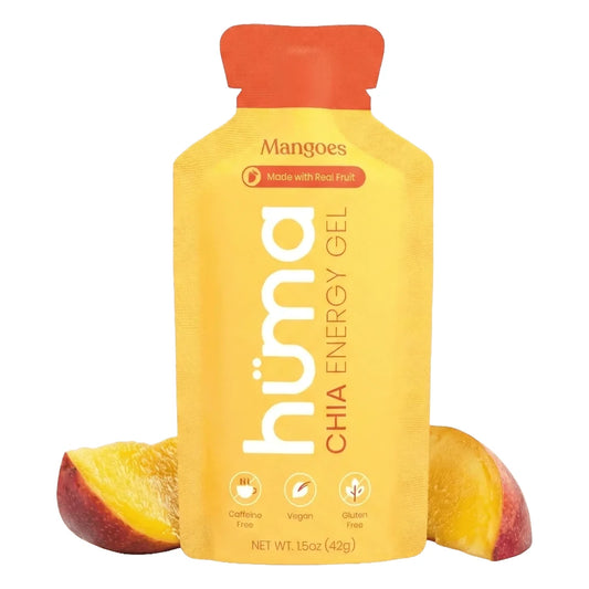 Huma Chia Energy Gel Mangoes flavor 1.5oz packet front hero on white background showing yellow gold packet with orange cap, Mangoes flavor name, Made with Real Fruit badge, h√ºma Chia Energy Gel branding, and Caffeine Free Vegan and Gluten Free icons, flanked by fresh mango slices