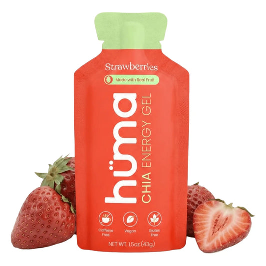 Huma Chia Energy Gel Strawberry flavor 1.5oz packet front hero on white background showing red packet with green cap, Strawberries flavor name, Made with Real Fruit badge, h√ºma Chia Energy Gel branding, and Caffeine Free Vegan and Gluten Free icons, flanked by fresh strawberries