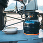 Ignik Gas Growler 3.8 lb refillable propane tank connected to a camp stove on an outdoor camp kitchen table