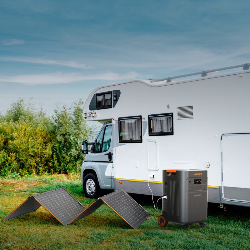 Jackery Explorer 5000 Plus solar generator powering an RV setup outdoors with solar panels deployed.