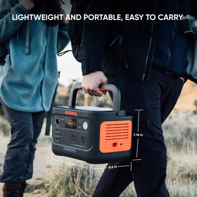 Person carrying Jackery Explorer 600 Plus portable power station with visible size dimensions.
