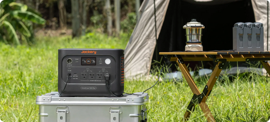 Jackery HomePower 1000 Plus v2 on a metal case at a campsite, powering a lantern and a drone battery charger