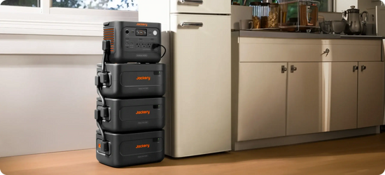 Jackery HomePower 1000 Plus v2 stacked on three expansion batteries beside a kitchen refrigerator