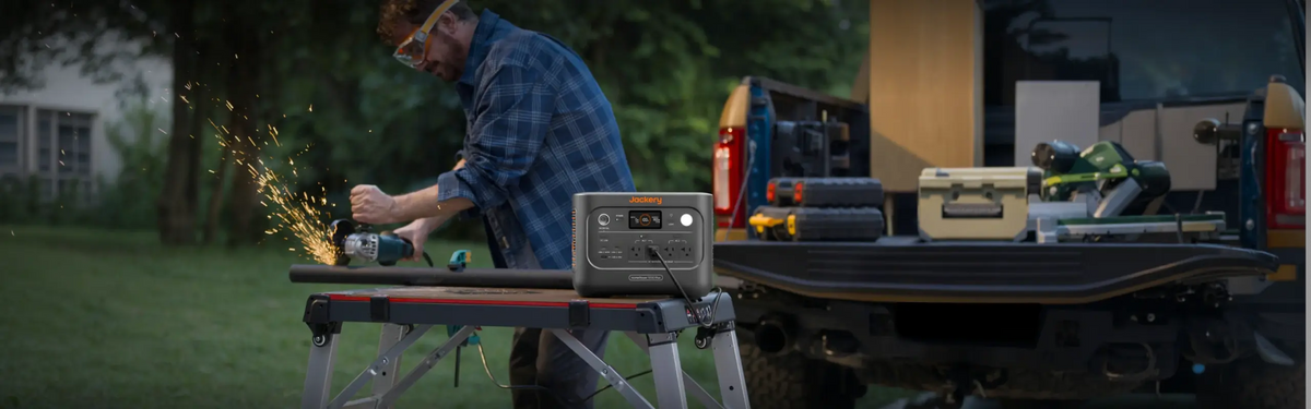 Man using an angle grinder at a work bench powered by the Jackery HomePower 1000 Plus v2 beside a pickup truck