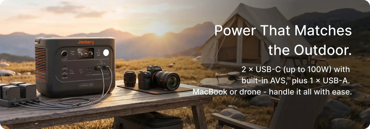 Jackery HomePower 1000 v2 charging camera batteries on a picnic table at a mountain campsite at sunset
