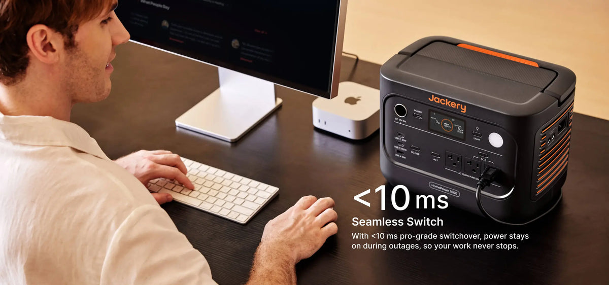 Man working at a desktop computer backed up by the Jackery HomePower 1000 v2 with under 10ms UPS switchover