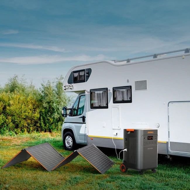 Jackery SolarSaga 340X solar panels connected to a power station beside an RV parked in the sun.