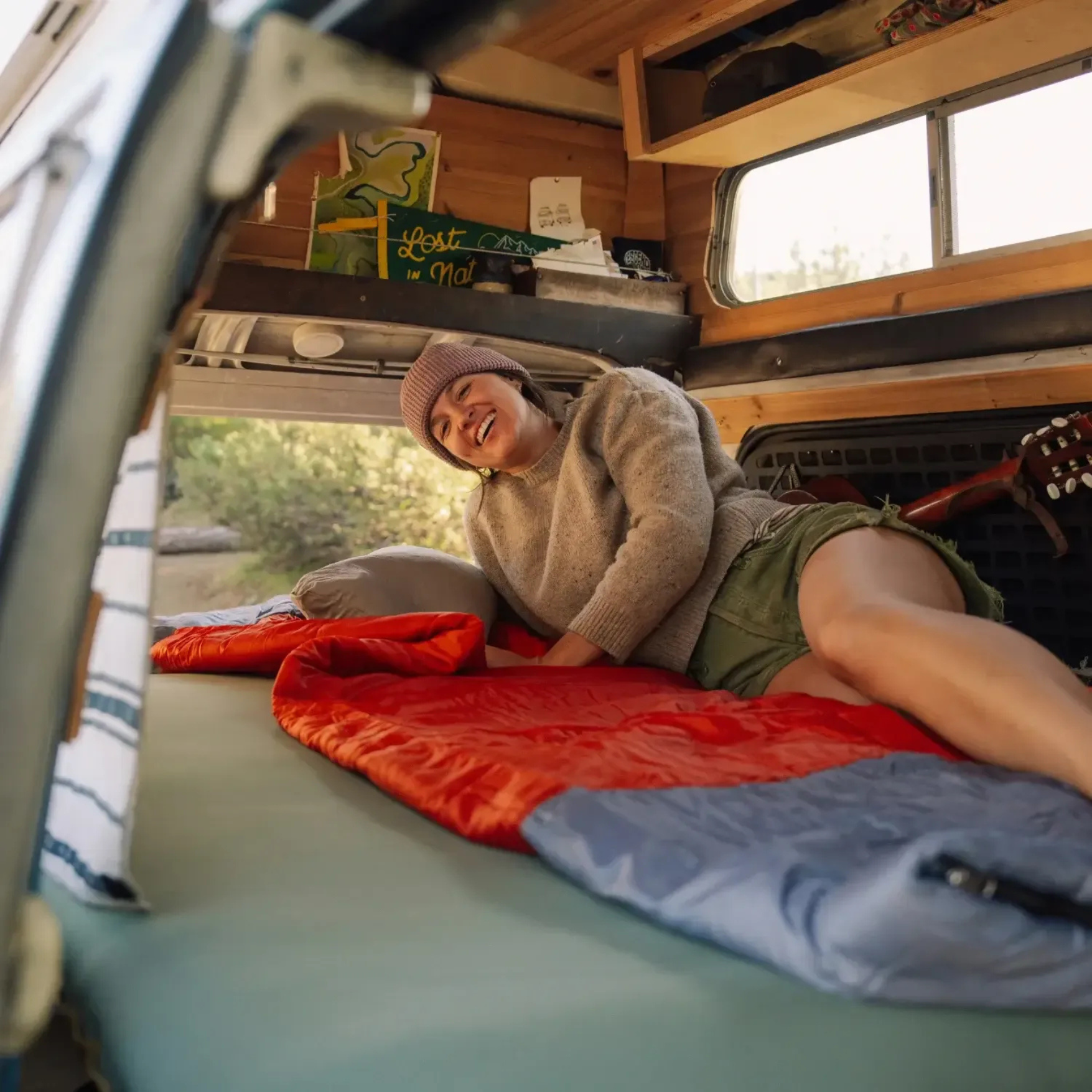 person relaxing on Klymit Bozeman 35 Large sleeping bag inside van camper setup