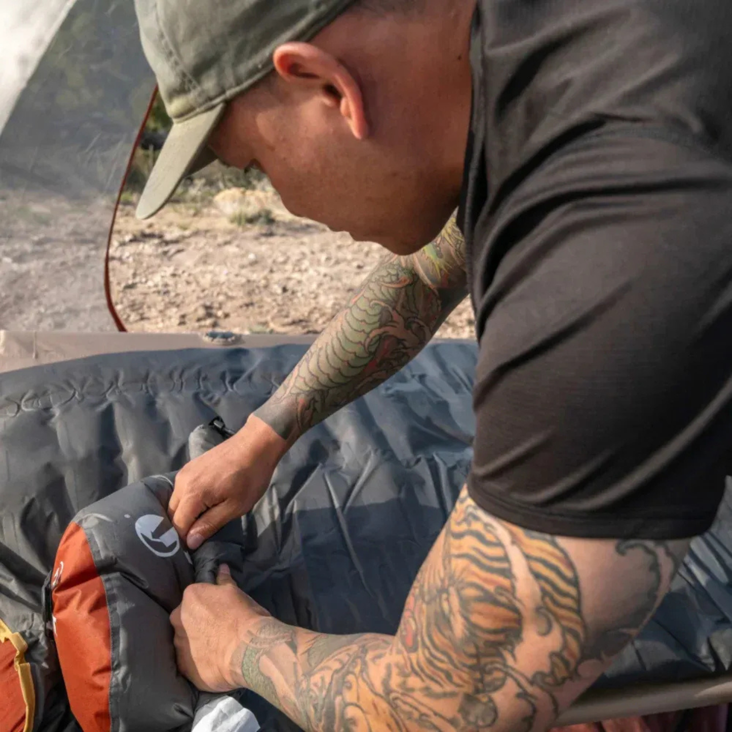Camper adjusting Klymit Insulated Klymaloft Peak XL sleeping pad inside tent during setup