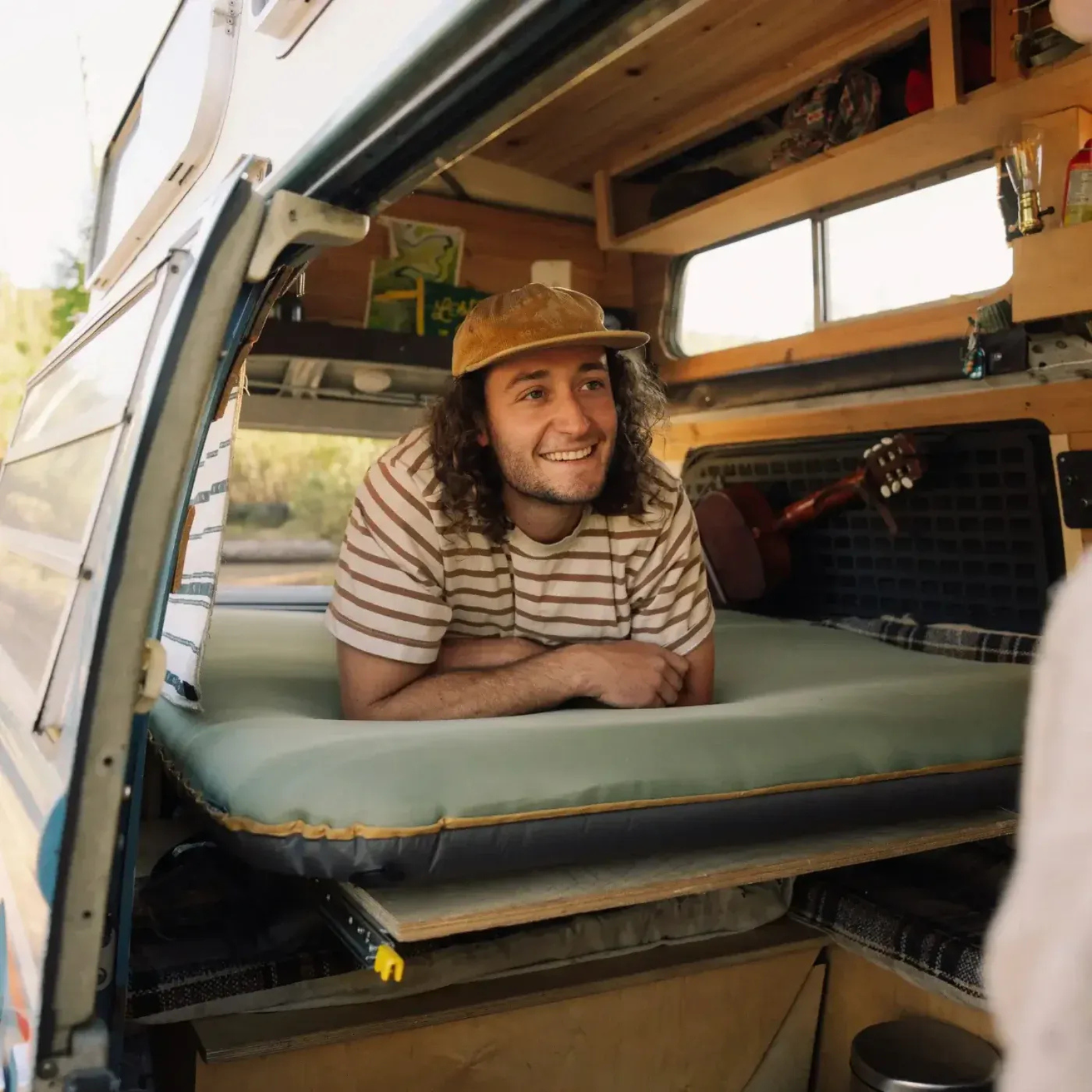 Man lying comfortably on Klymit Klymaloft Summit double sleeping pad inside camper van setup