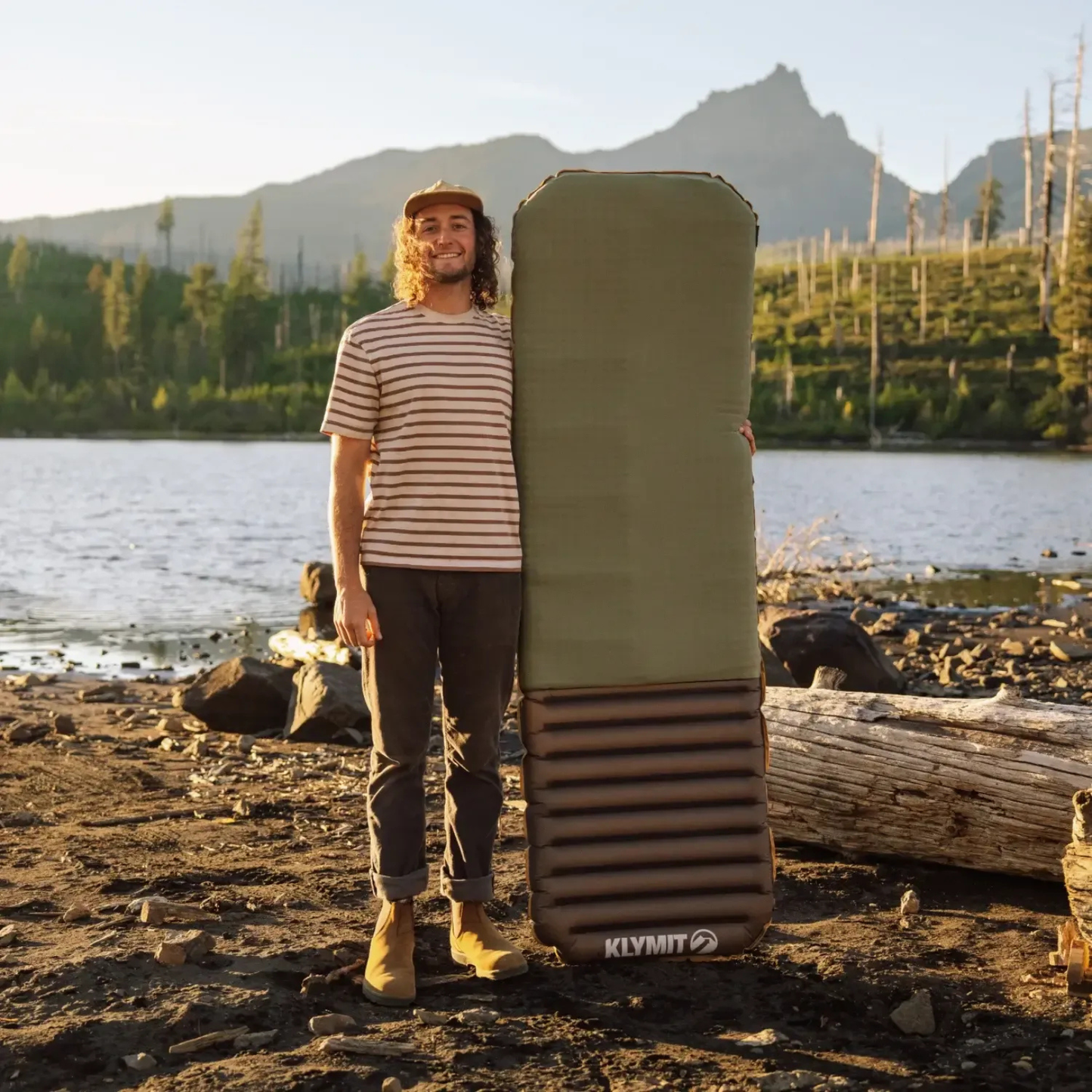 Man standing with Klymit Klymaloft Summit sleeping pad showing full size outdoor sleeping gear