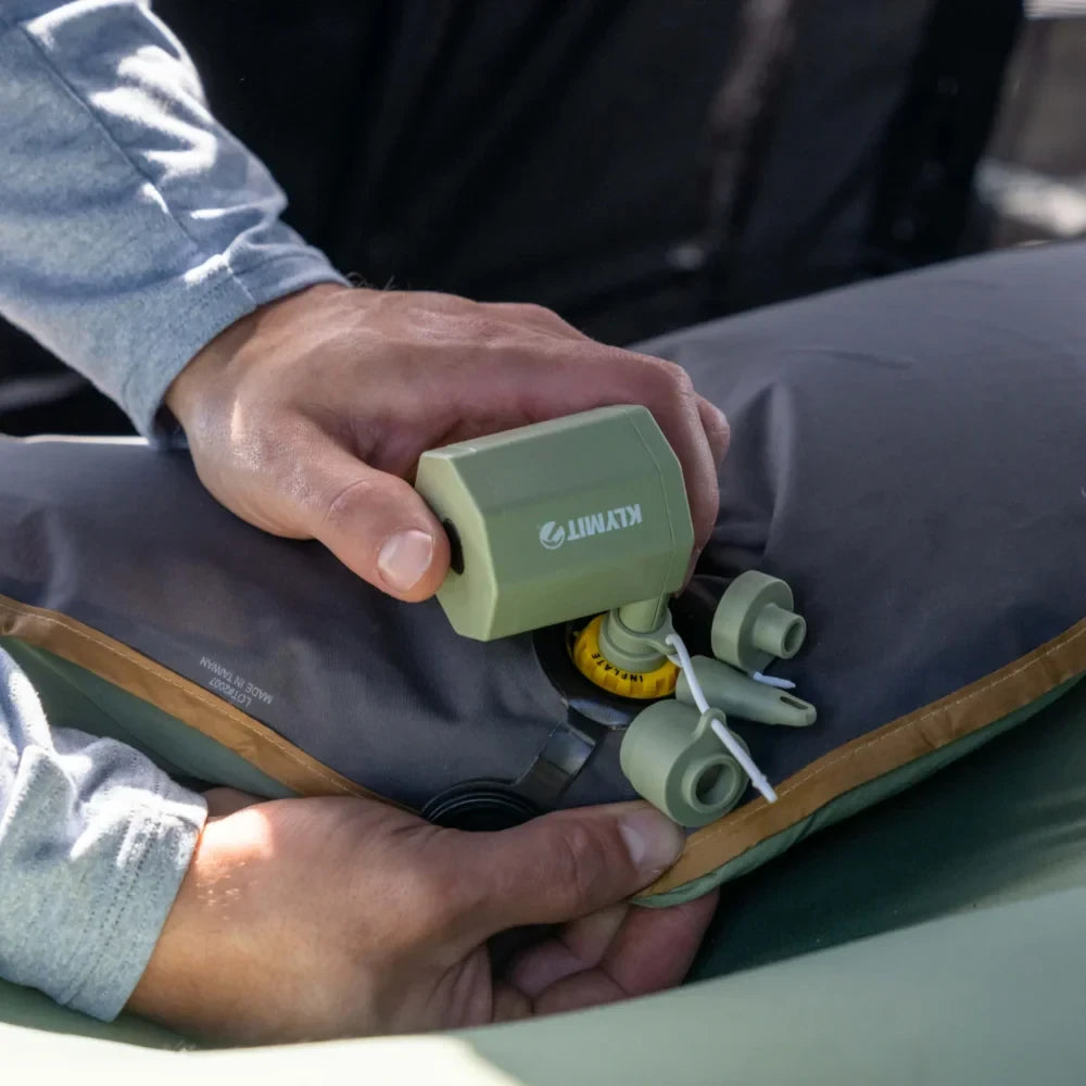Klymit Tempest USB Pump attached to camping sleeping pad for fast cordless inflation outdoors.