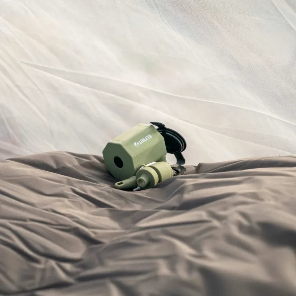 Tempest USB Pump resting on sleeping pad inside tent showing compact portable outdoor design.