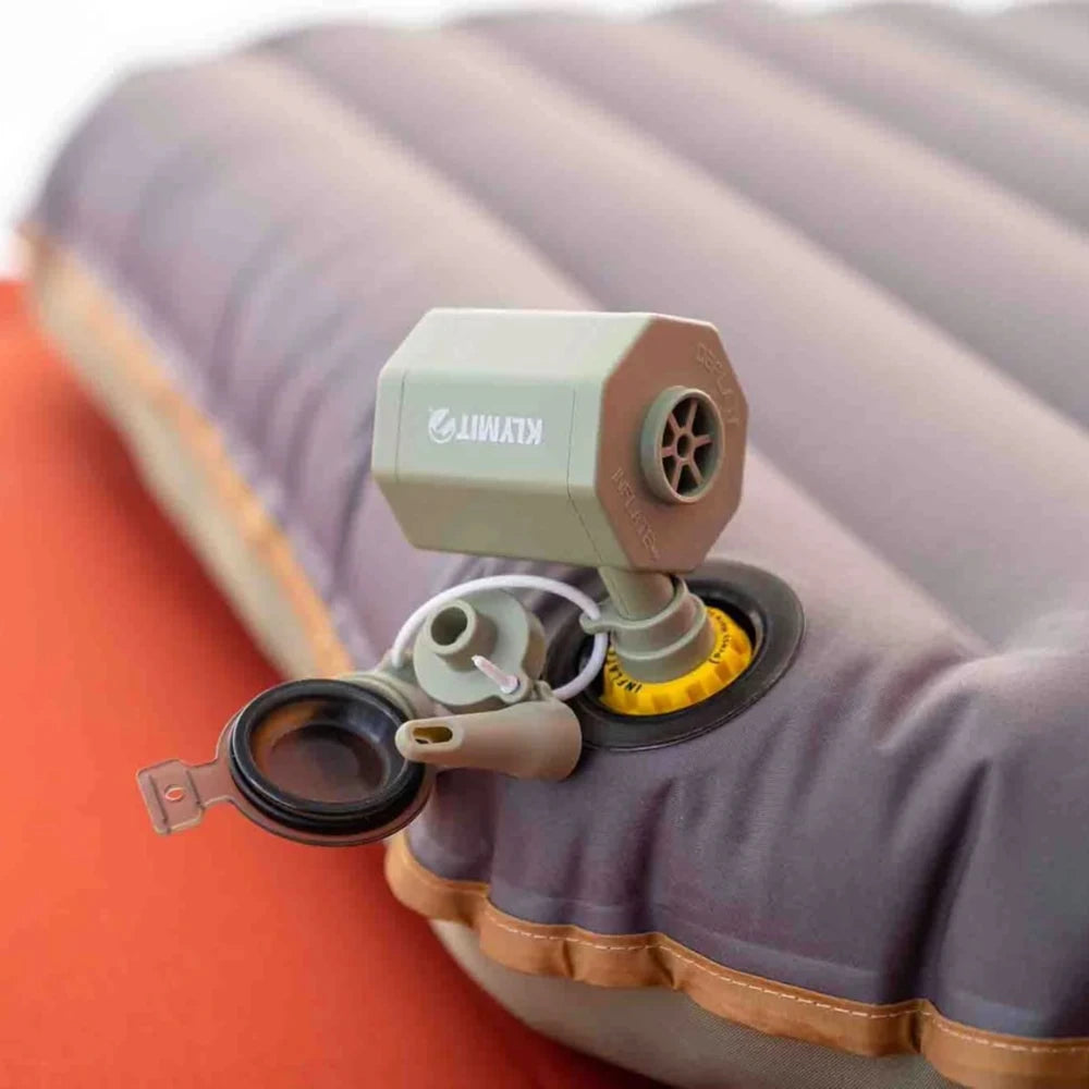 lose-up of Klymit Tempest USB Pump portable electric air pump connected to sleeping pad valve.
