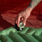 Klymit Tempest USB Pump inflating green camping sleeping pad inside tent for lightweight outdoor sleep setup.