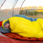 Person sleeping in Klymit Wild Aspen 0 sleeping bag inside tent during outdoor camping