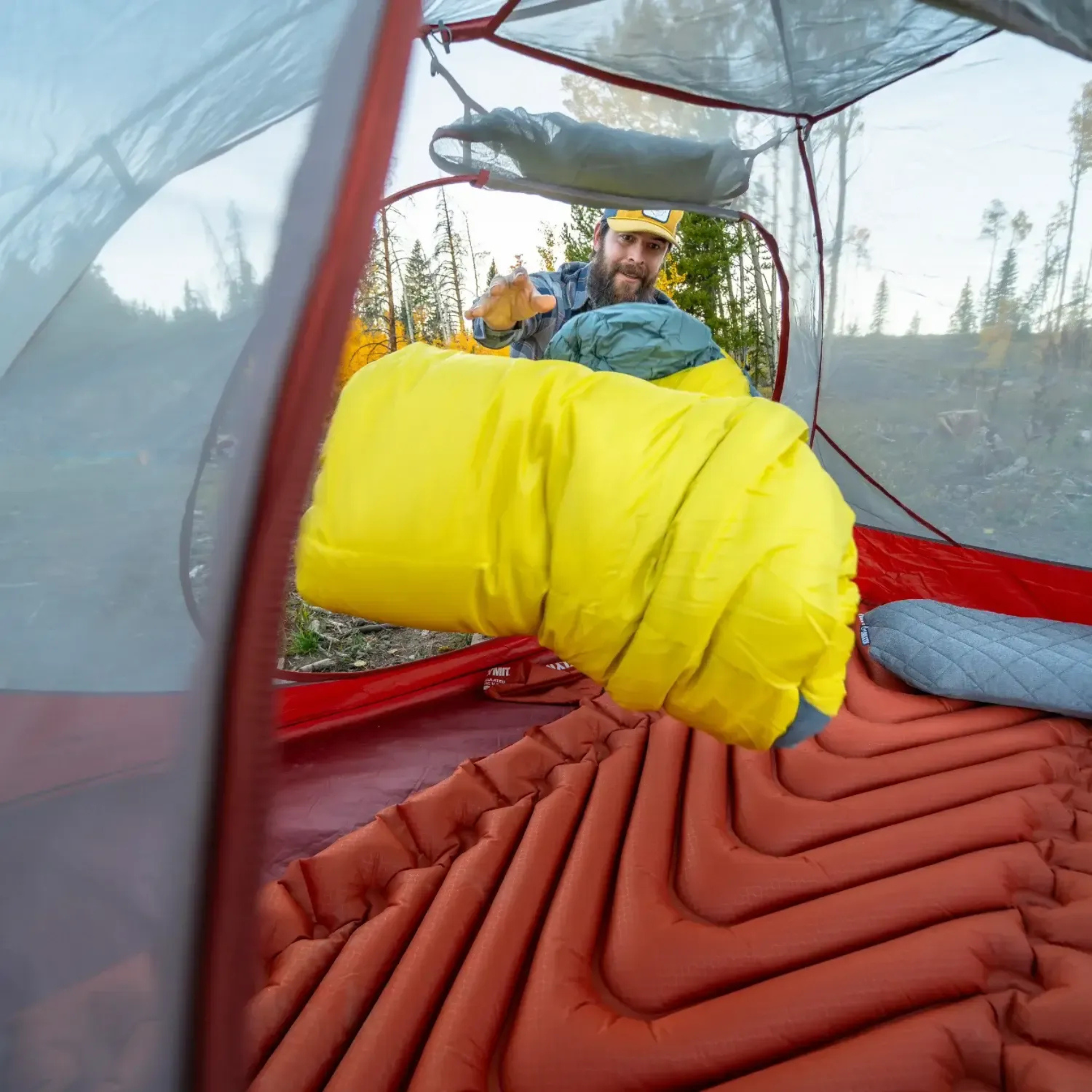 Klymit Wild Aspen 0 sleeping bag being placed inside tent on sleeping pad