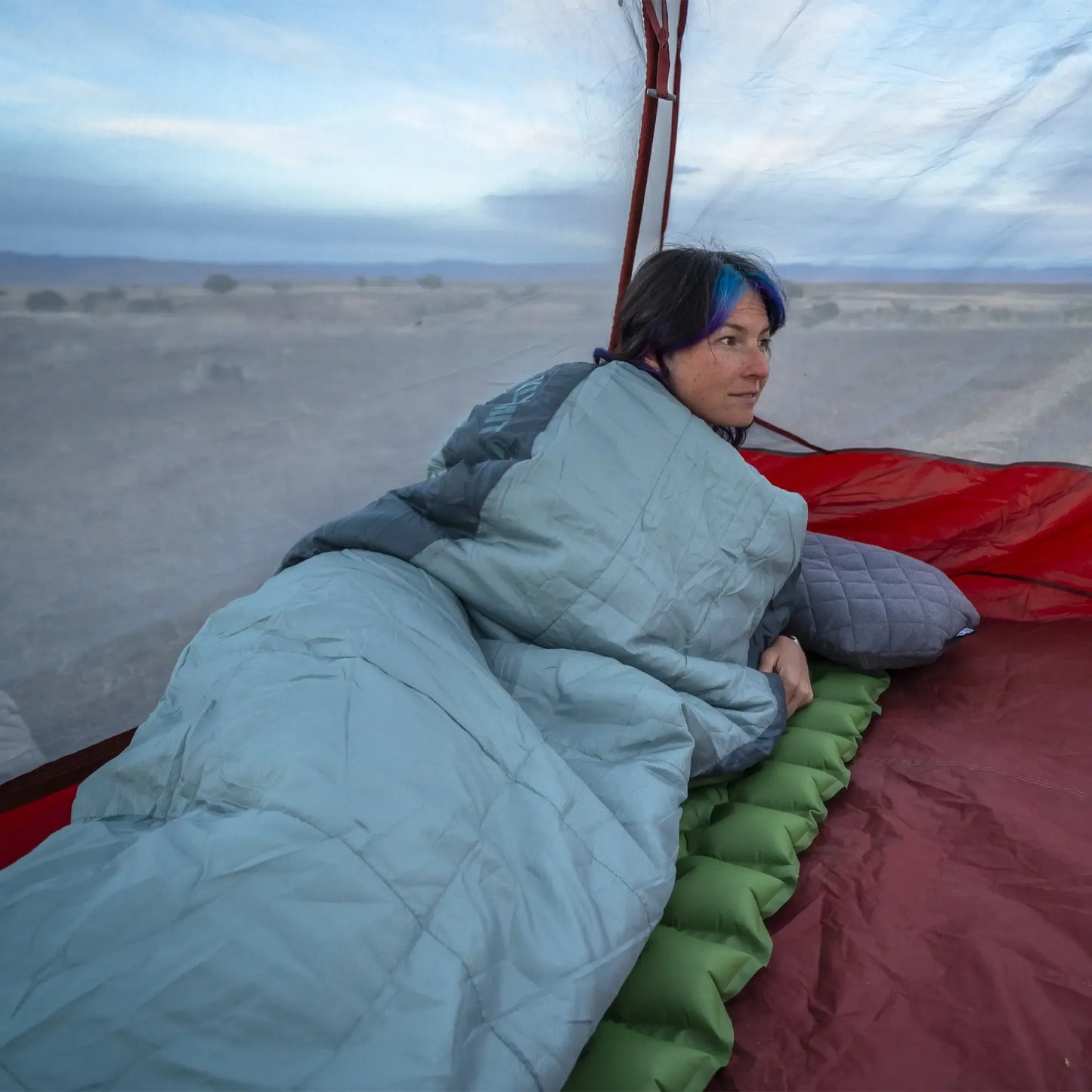 person resting inside tent using Klymit Wild Aspen 20 sleeping bag on sleeping pad