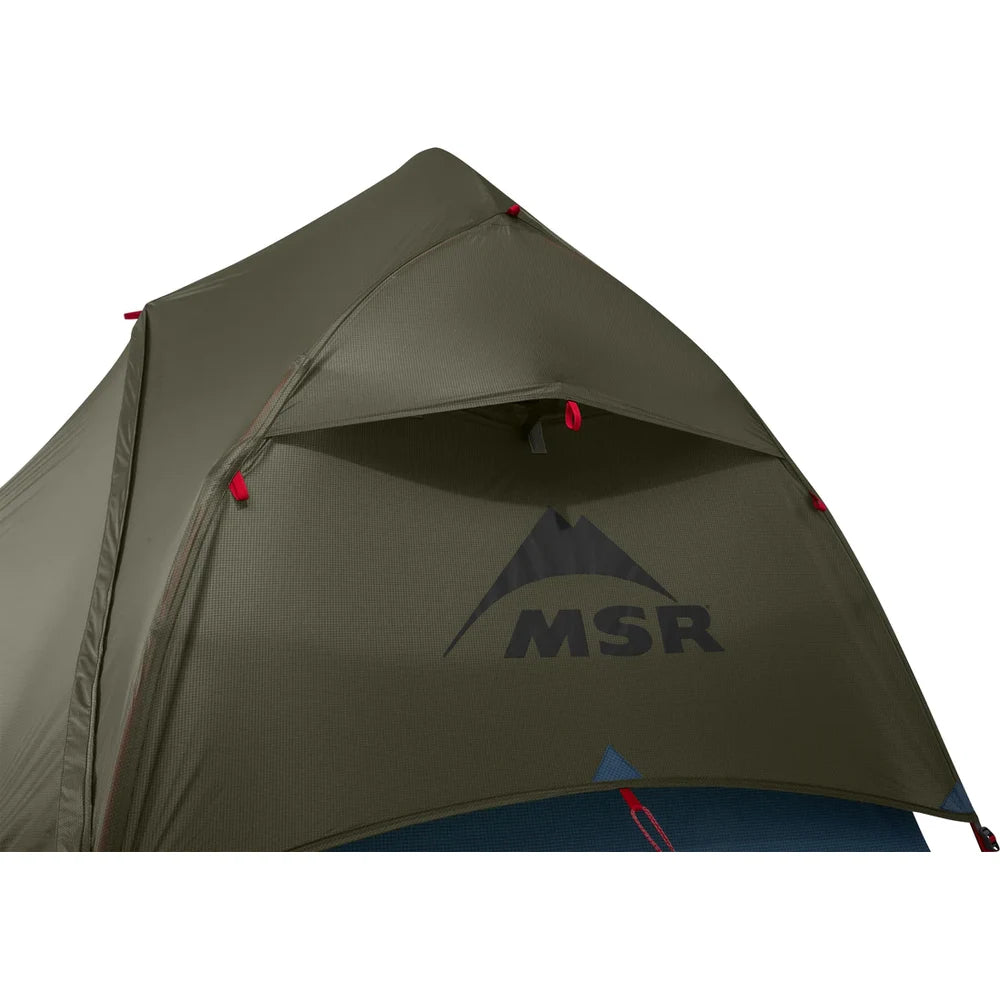 Close-up of MSR Hubba Hubba HD 1 tent rainfly showing kickstand vent opening and MSR mountain logo on olive green 20D ripstop nylon waterproof fabric