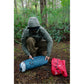 Solo backpacker in rain gear unrolling MSR Hubba Hubba HD 1 tent body on forest floor during rainy Vancouver Island backpacking trip demonstrating quick setup