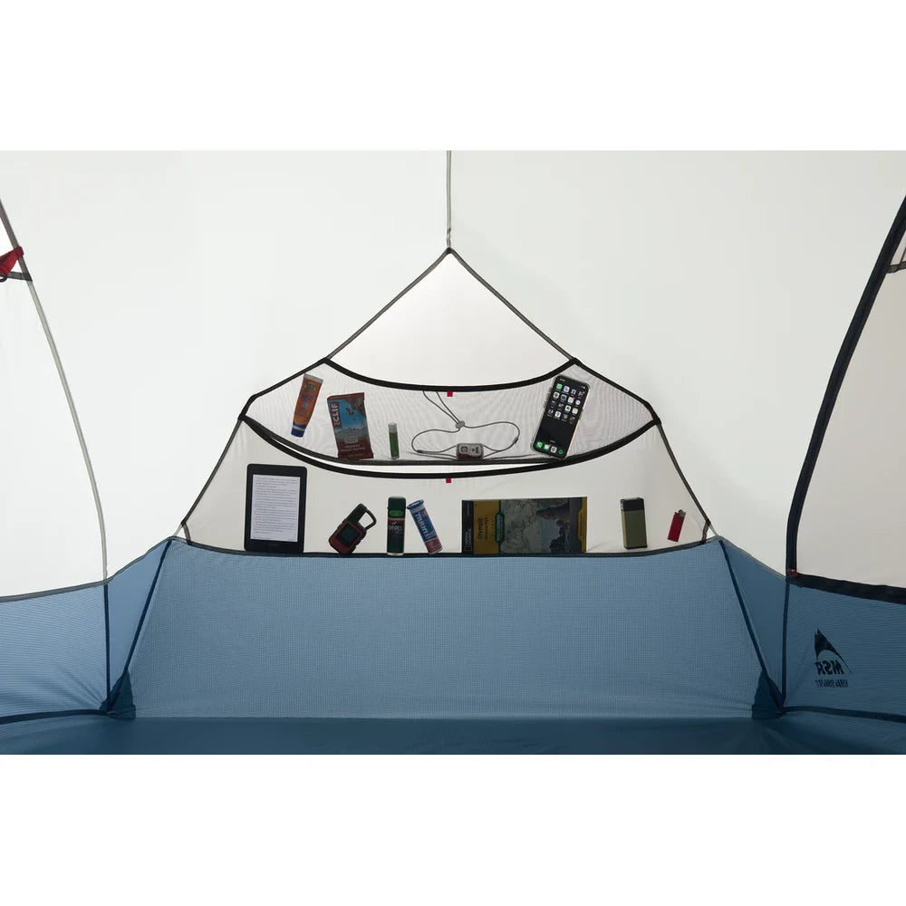 MSR Hubba Hubba HD 2 tent interior end pocket and hanging organizer loaded with phone, e-reader, snacks, lantern, map book, and camp essentials