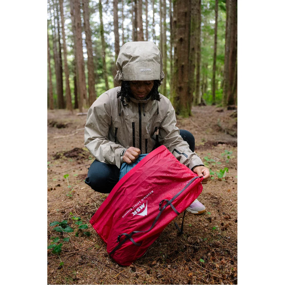 MSR Hubba Hubba HD 3-Person tent being pitched at forested backcountry campsite on rainy Vancouver Island showing easy symmetrical setup design