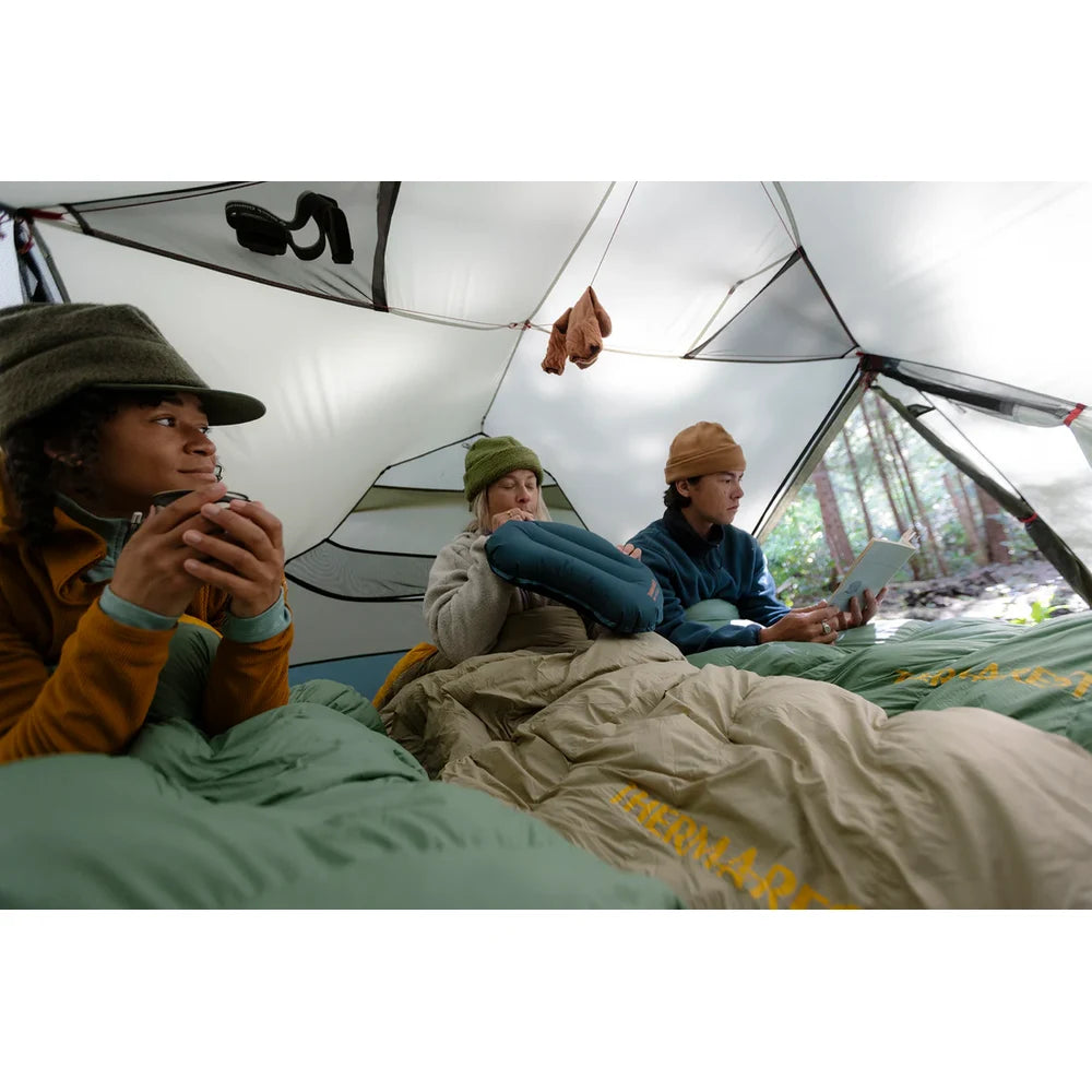 Three campers relaxing inside spacious MSR Hubba Hubba HD 3-Person tent interior with Therm-a-Rest sleeping bags during rainy Vancouver Island backpacking trip