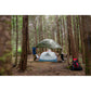 Three backpackers setting up MSR Hubba Hubba HD 3-Person tent in Pacific Northwest old-growth forest during rainy conditions on Vancouver Island backpacking trip