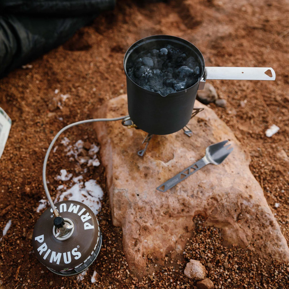 Primus fuel canister connected to portable camping stove setup