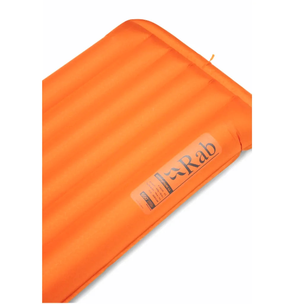 Close-up of the orange top surface and horizontal baffles of the Rab Hypersphere 9.5 down sleeping mat with Rab logo label