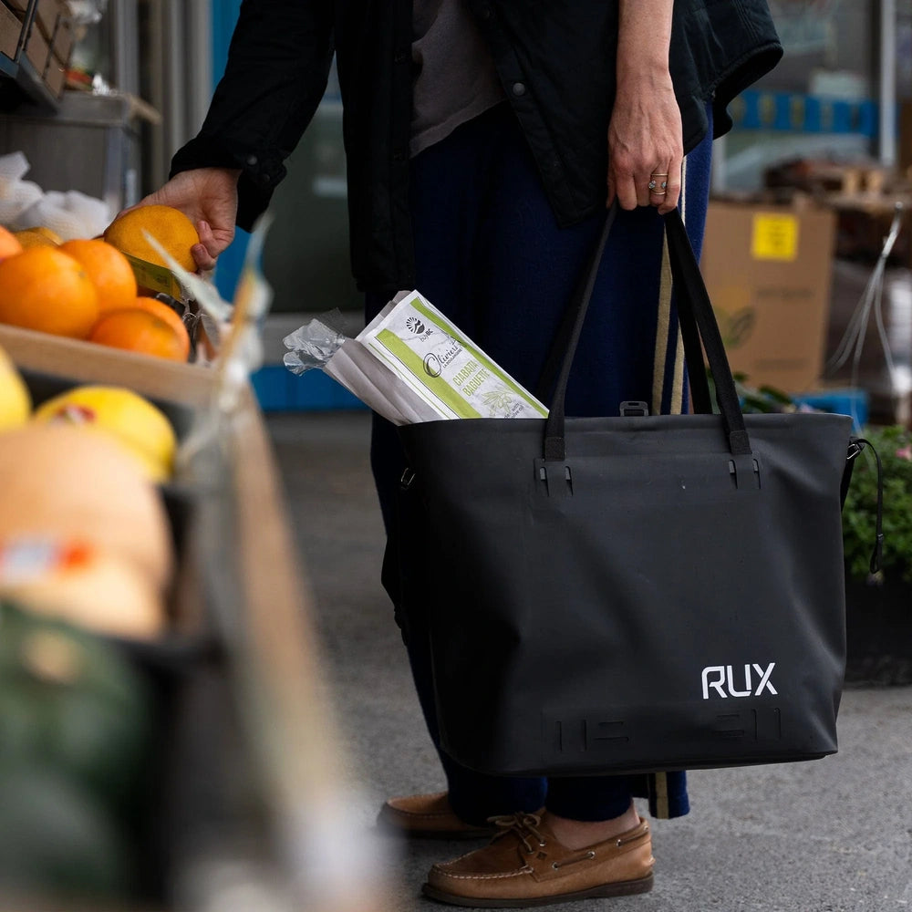 RUX 30L Waterproof Tote lifestyle image featuring black waterproof tote grocery shopping lifestyle