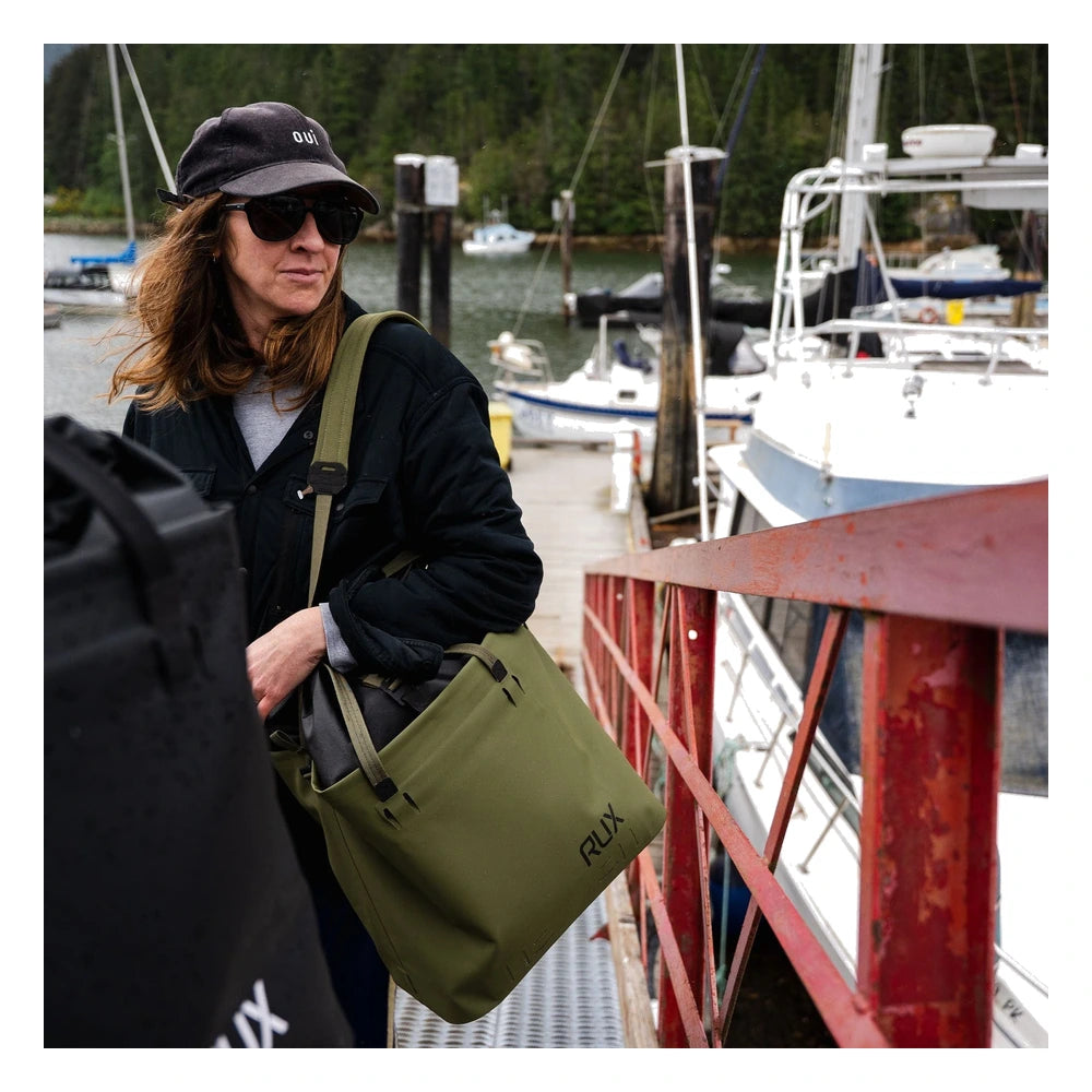 RUX 30L Waterproof Tote in green carried over shoulder at marina