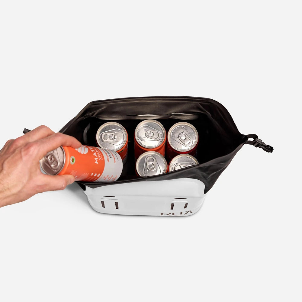 RUX 5L Cooler in white with a hand placing a can into the insulated interior.