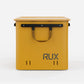 Rux 70L Press-Seal bronze container front view showing carry handle, reinforced rail system, vent slots, and hard storage shell.