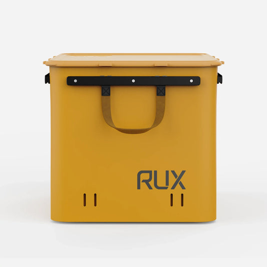 Rux 70L Press-Seal bronze container front view showing carry handle, reinforced rail system, vent slots, and hard storage shell.